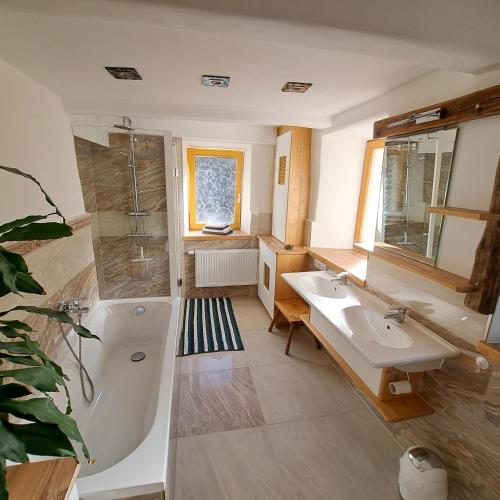 a bathroom with a tub and a sink and a bath tub at "Hisel-Haus" in Techelsberg am Worthersee