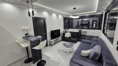 a living room with a blue couch and a television at B&O Seaview in Bar