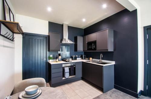 a kitchen with blue walls and a stove top oven at The Mariner's Rest Aparthotel in Cleethorpes