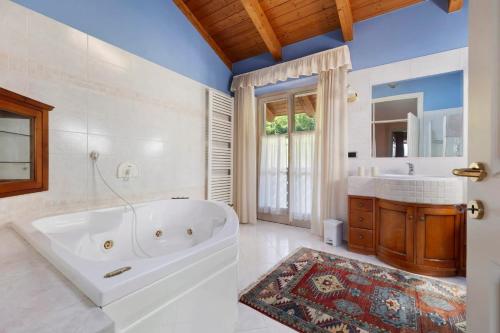 a white bathroom with a tub and a sink at Bnb Casa Fiore in Madice