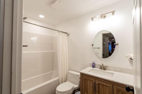 a bathroom with a toilet and a sink and a mirror at Cedar Retreat in McGaheysville