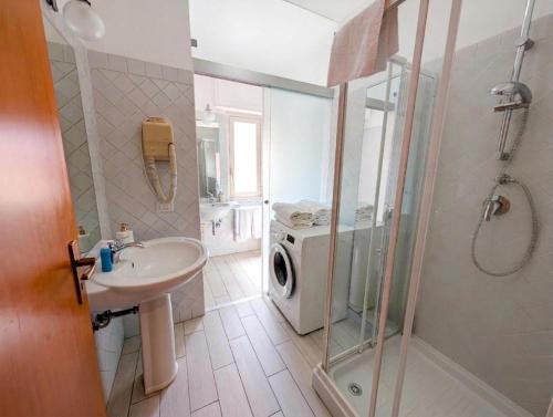 a bathroom with a sink and a washing machine at Attico al Centro in Cefalù