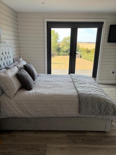a bedroom with a large bed with a large window at Danielle’s den in Doncaster