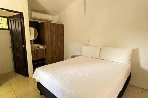 a bedroom with a white bed and a mirror at Club Voca 5 in Coco