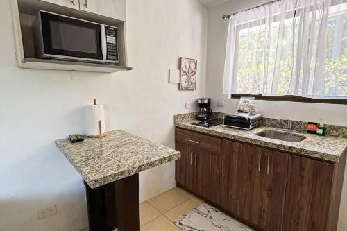 a small kitchen with a sink and a microwave at Club Voca 5 in Coco