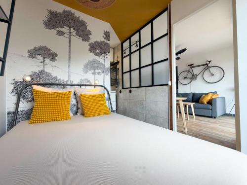 a bedroom with a bed with yellow pillows and a bike on the wall at Balcon Vue Panoramique - Parking - Gare 200m in Vienne