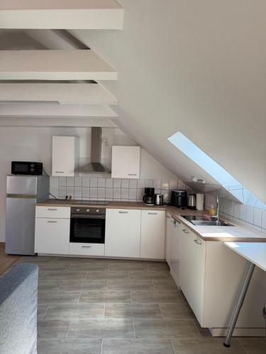 a kitchen with white cabinets and a roof at Elbstone 2 in Wittenberge