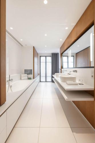 a large bathroom with two sinks and two mirrors at Hôtel C2 in Marseille