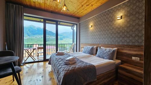a bedroom with a bed and a large window at Best view Kazbegi in Kazbegi