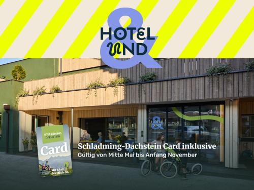 a building with a hotel and a sign in front at Hotel UND - smart alpine stay in Schladming