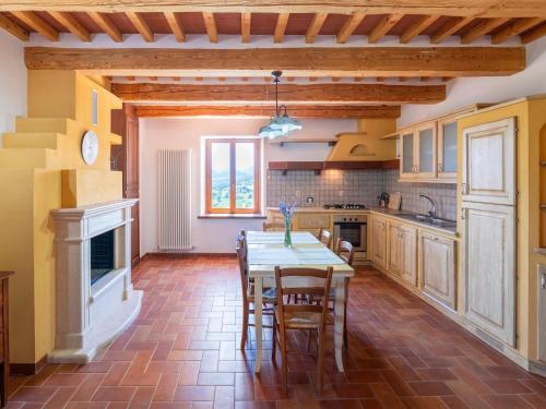 a kitchen with a table and chairs in a room at Apartment in a farmhouse with 2 swimming pools in Cagli