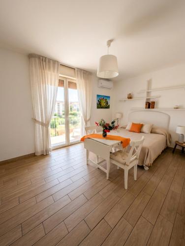 a bedroom with a bed and a desk and a table at Attico al Centro in Cefalù