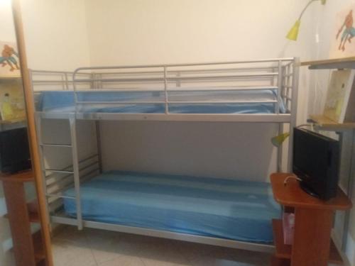 a room with two bunk beds and a television at CASA VACANZA Torre Lapillo PREMIUM in Torre Lapillo