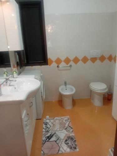 a bathroom with a sink and a toilet at CASA VACANZA Torre Lapillo PREMIUM in Torre Lapillo