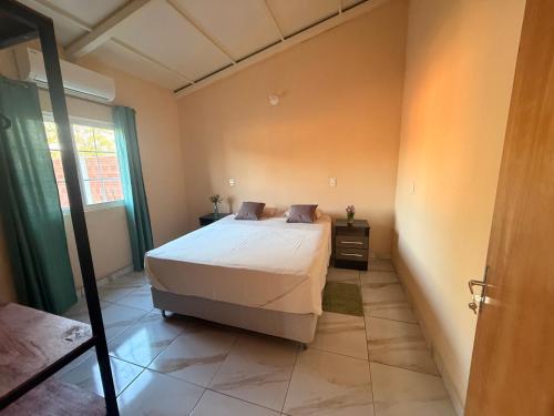 a bedroom with a large bed and a window at Casa Verde in Mbocayaty