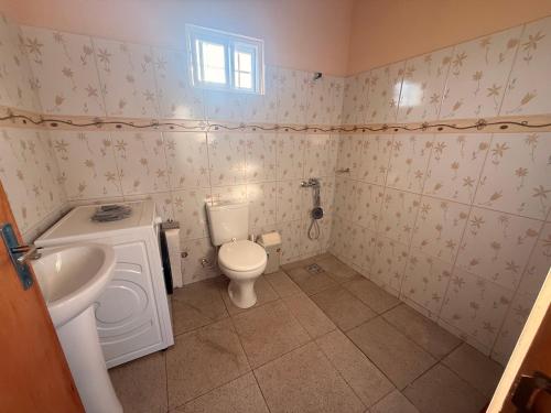 a small bathroom with a toilet and a sink at Casa Verde in Mbocayaty