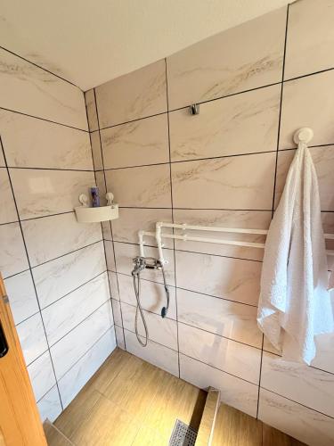 a shower in a bathroom with white tiles at Naš raj in Berane