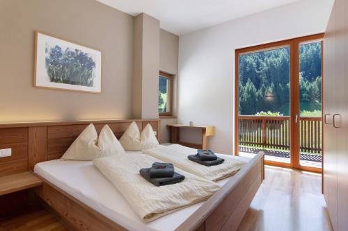 a bedroom with a bed with two towels on it at Pritscheshof Ferienwohnung Balkon in Malles Venosta
