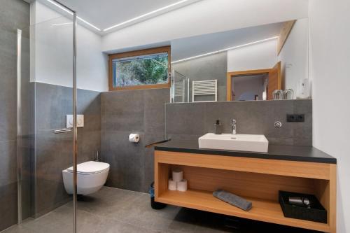 a bathroom with a sink and a toilet and a mirror at Pritscheshof Ferienwohnung Balkon in Malles Venosta