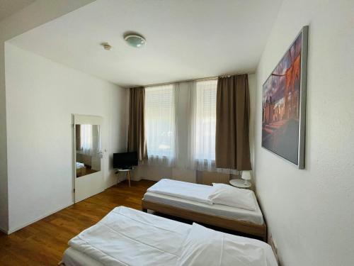 a hotel room with two beds and a window at Hotel Westend in Cologne