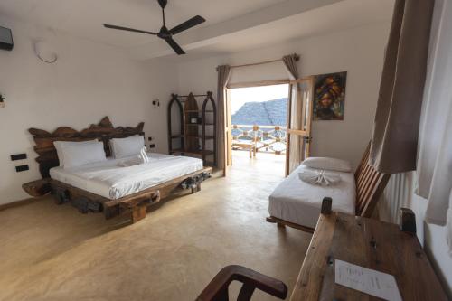 a bedroom with two beds and a sliding glass door at Faro Resort in Nungwi