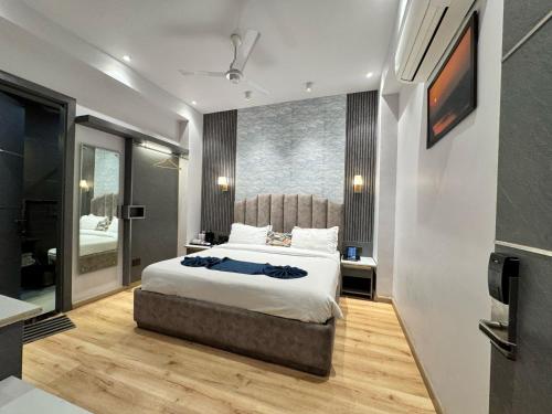 a bedroom with a large bed and a television at Hotel Azul Ganga in Rishīkesh