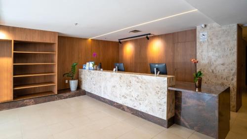 a lobby with a reception desk in a building at Naoum Hotel in Brasília