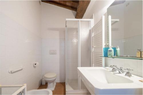 a white bathroom with a sink and a toilet at Casa Bolgheri Castagno in Bolgheri