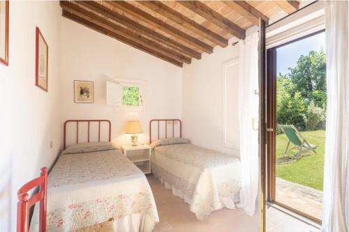 two beds in a room with a window at Casa Bolgheri Castagno in Bolgheri