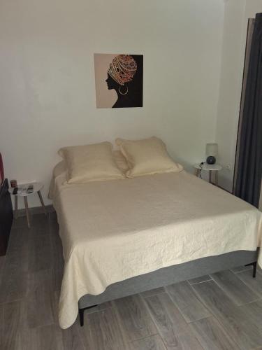 a bedroom with a bed with white sheets at villa Kanel in Le Robert