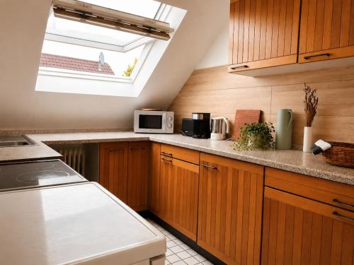 a kitchen with wooden cabinets and a window at Odw homes - 3Room Apartment for Workers in Weinheim