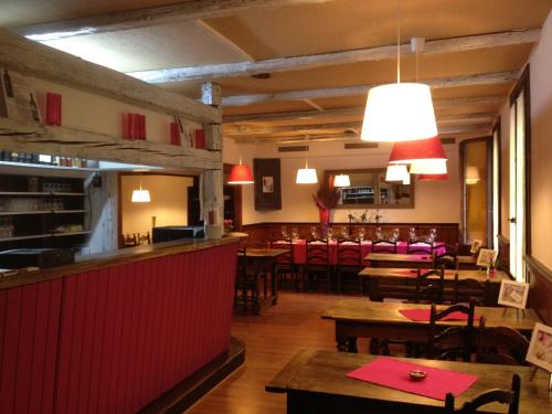 un restaurante con mesas y sillas de madera y un bar en Chambre d’hôtes des Fées, en Épinassey