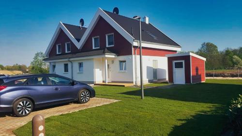 a blue car parked in front of a house at Ferienhaus Klabautermann 53 - Nordhorn in Nordhorn