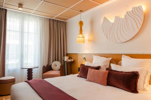 a hotel room with a bed and a pendant at Posidonia Hôtel in Nice