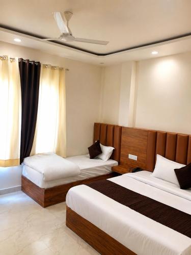 a hotel room with two beds and a window at Velora hotele in Amritsar