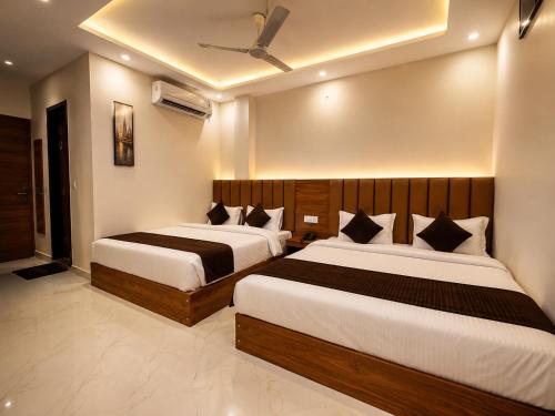two beds in a hotel room with two beds at Velora hotele in Amritsar