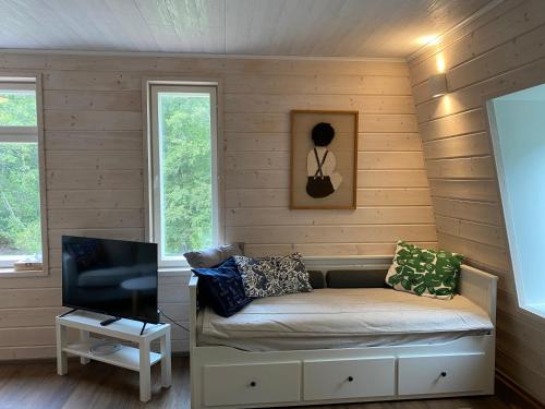 a room with a couch in a room with wooden walls at Idyllic Charm- with a moat! in Kangasala