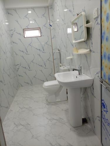 a white bathroom with a sink and a toilet at MSM Diamond Villa in Wattala
