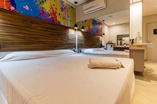 a large white bed in a bedroom with a wall at Soft Motel - USP in São Paulo