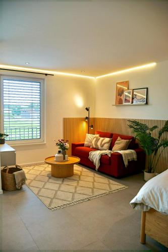 a living room with a red couch and a table at SmartStay in Gronau