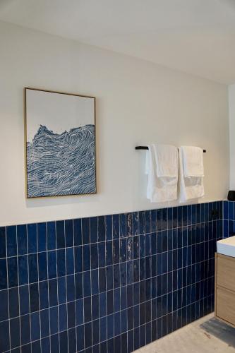 a blue tiled bathroom with a picture on the wall at SmartStay in Gronau