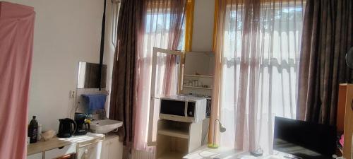 a kitchen with a microwave and a window at Aangenaam & redelijk geprijsd in Amersfoort
