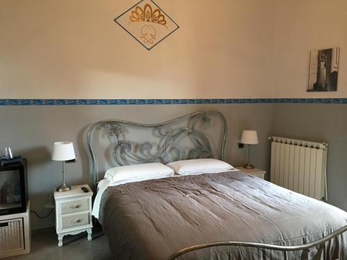 a bedroom with a bed and two night stands and a tv at Le Divine - Reception Via XXV Aprile 5 in Levanto