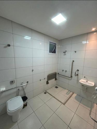 a bathroom with a toilet and a sink at Vinds Economic Hotel in Ipatinga