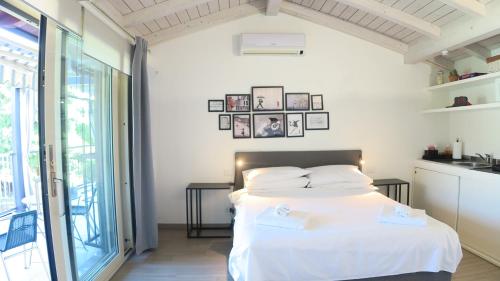 a bedroom with a white bed and a balcony at OnSuite With Wiew Near COMO in Erba