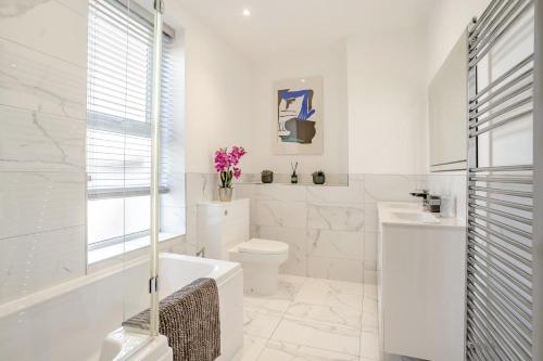 a white bathroom with a tub and a toilet and a sink at 3 Bed in Cardiff oc-bow188 in Cardiff