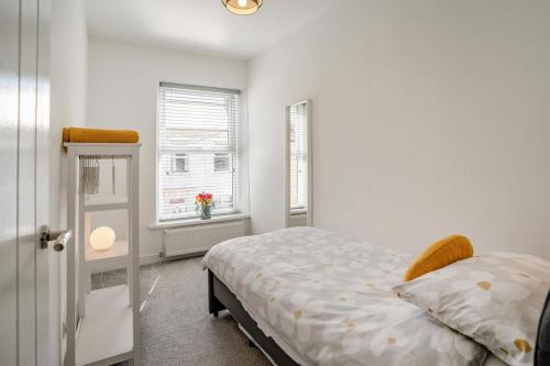 a white bedroom with a bed and a window at 3 Bed in Cardiff oc-bow188 in Cardiff