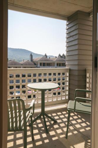 a patio with a table and chairs on a balcony at Volume Nord - Loft de montagne in Stoneham