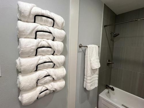 a stack of towels hanging on the wall of a bathroom at Healing Haven King Bed Suite in Dallas