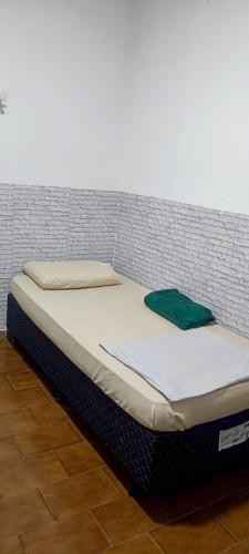 a bed sitting against a brick wall at Pousada Popular in Barreiras